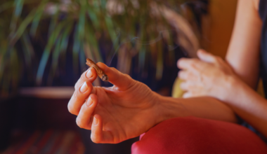 A woman holds a cannabis joint in her hand.
