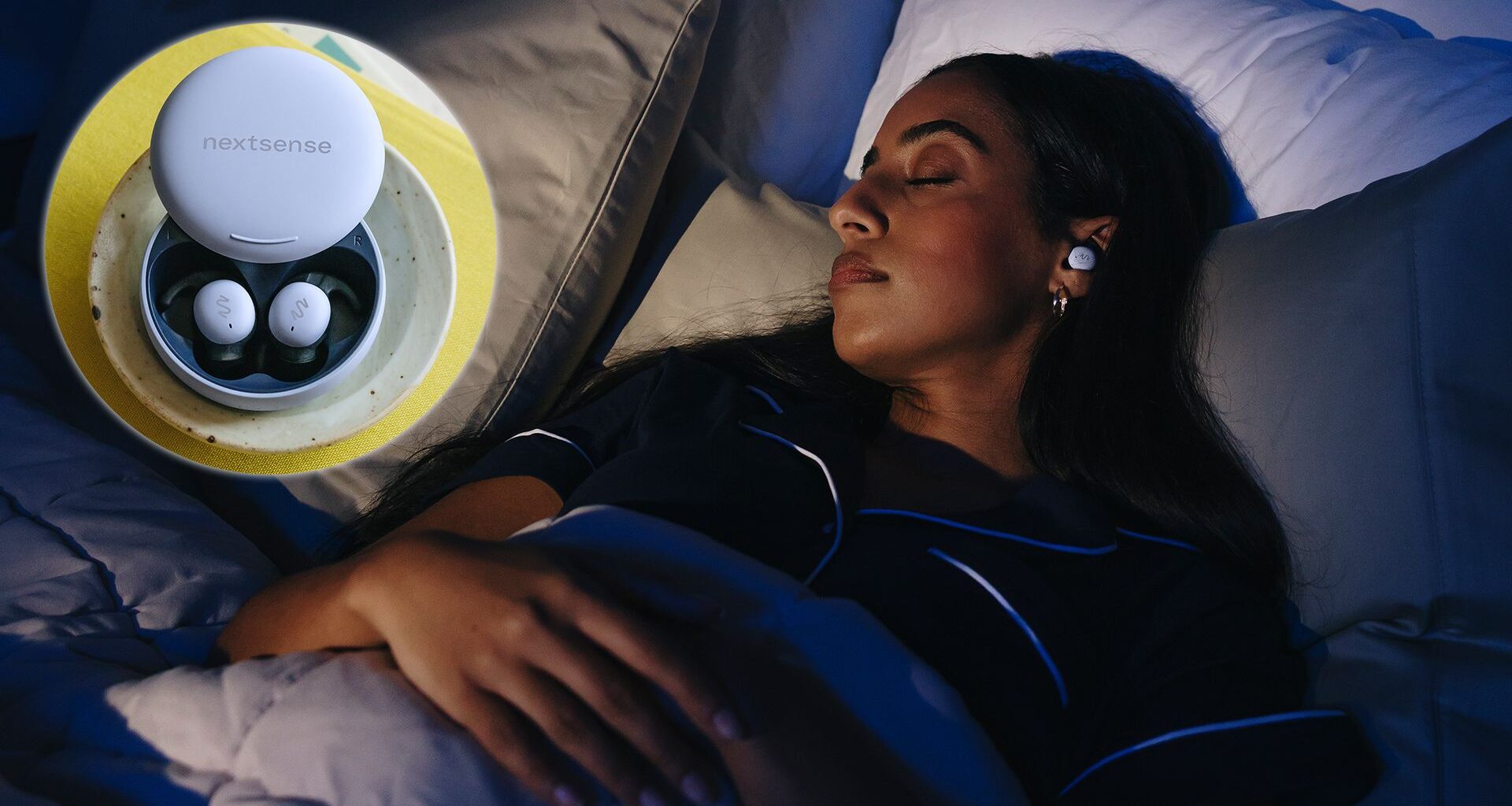 A woman lies on her back asleep in a dimly lit room wearing a pair of NextSense Smartbuds. In the top left corner, an indent image shows a close up of the Nextsense Smarbuds in their case