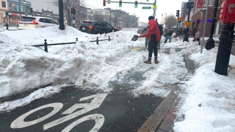 Cyclists clear snow from Comm. Ave. bike lanes, urge city action