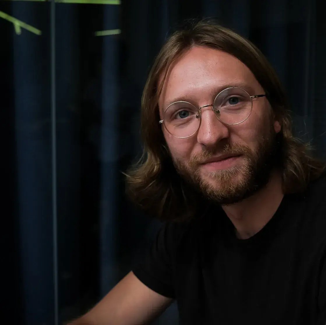 Man with glasses staring straight ahead.