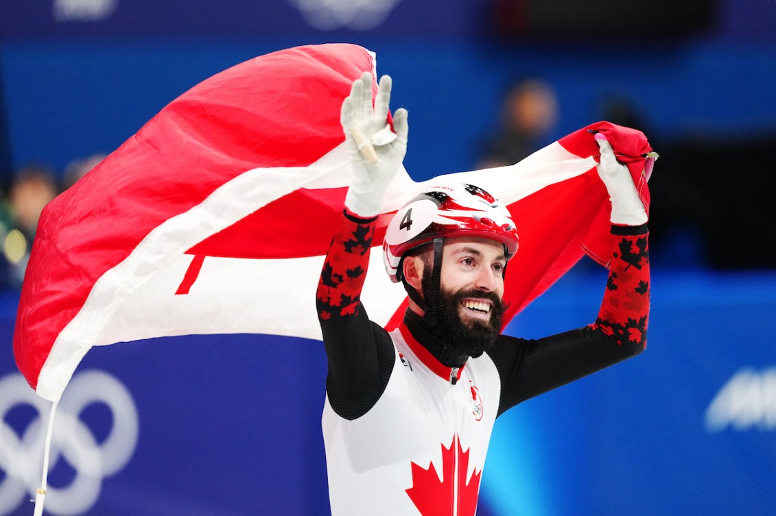 Team Canada's Steven Dubois celebrates winning gold in Short Track Speed Skating men's 500m