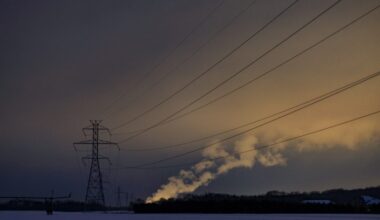 Power lines are silhouetted against a twilight sky.