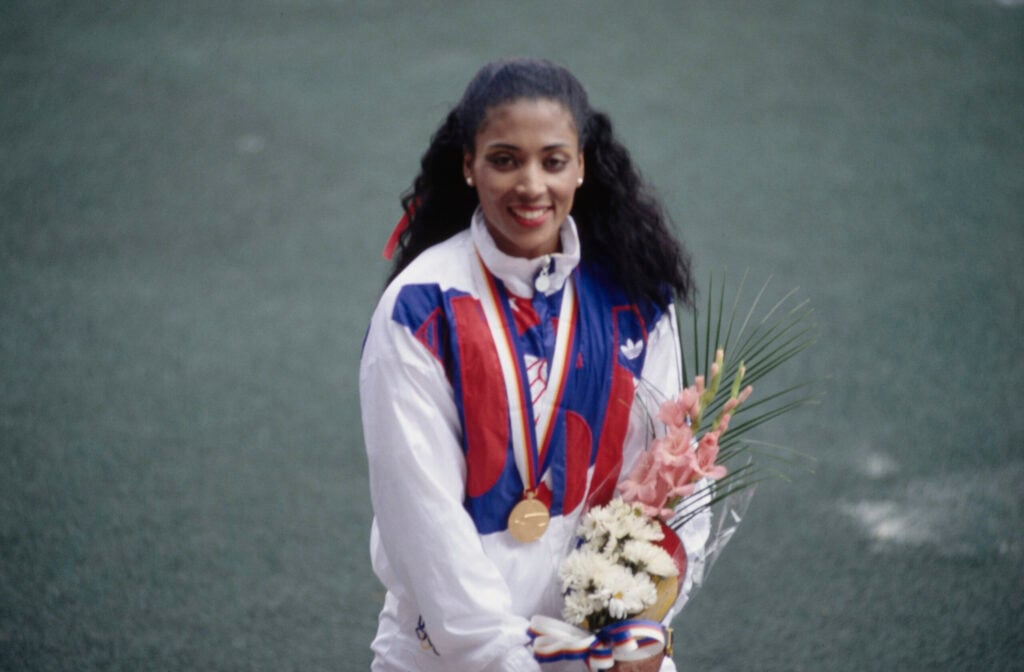 American athlete Florence Griffith Joyner on the winners' podium after receiving a gold medal for a women's track event at the 1988 Summer Olympics, held at the Seoul Olympic Stadium in Seoul, South Korea, September 1988. Griffith Joyner competed in the women's 100 metres, 200 metres, 4x100 metres, and 4x400 metres events at the Games. (Photo by Bongarts/Getty Images)