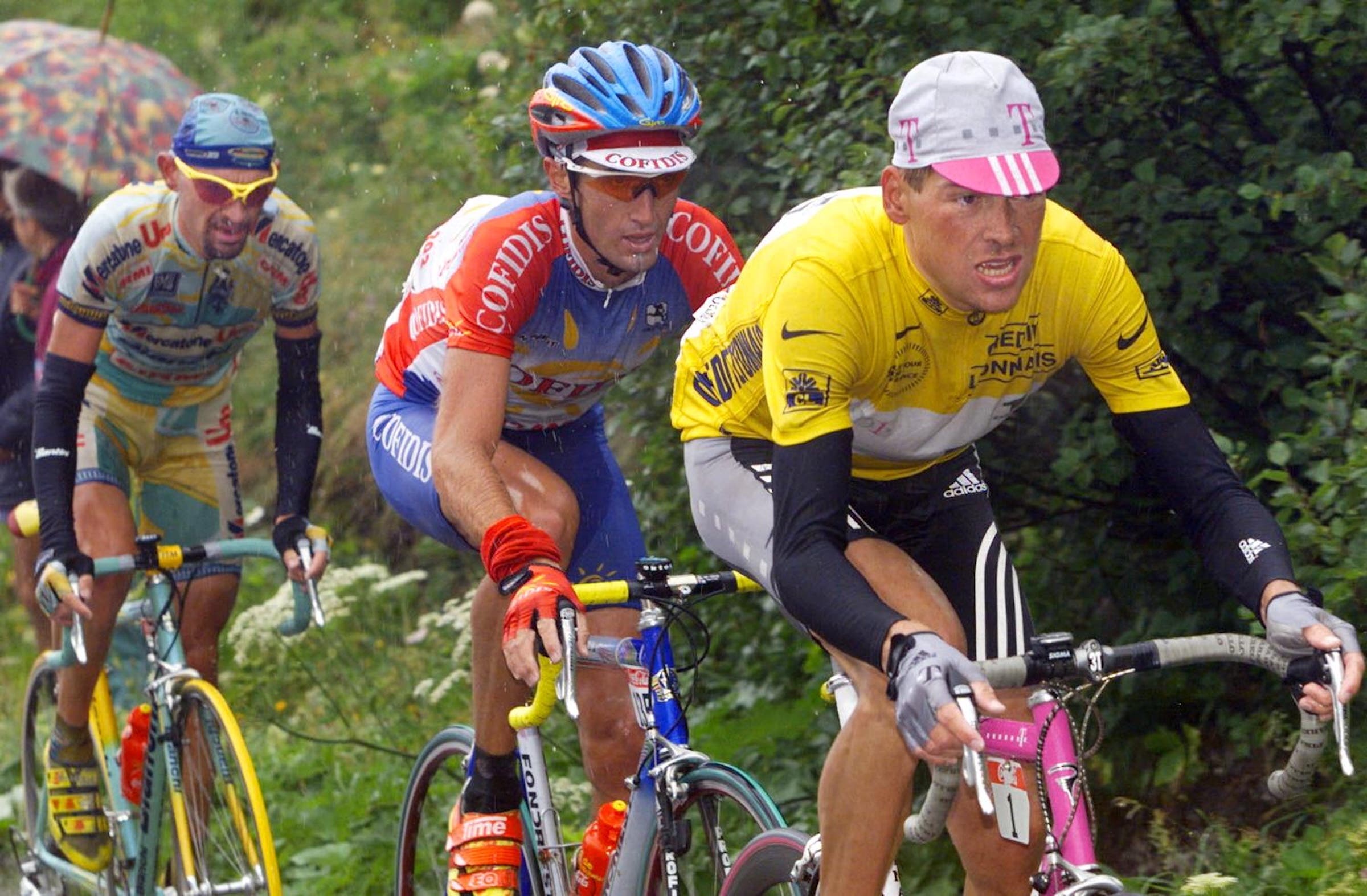 The yellow jersey German Jan Ullrich (R) rides with Italian Marco Pantani (L) and American Bobby Julich (C) during the 15th stage of the Tour de France between Grenoble and Les Deux Alpes, southern France, 27 July. Italian Marco Pantani won the stage and becomes the new yellow jersey. (ELECTRONIC IMAGE) AFP PHOTO (Photo by PASCAL PAVANI / AFP)