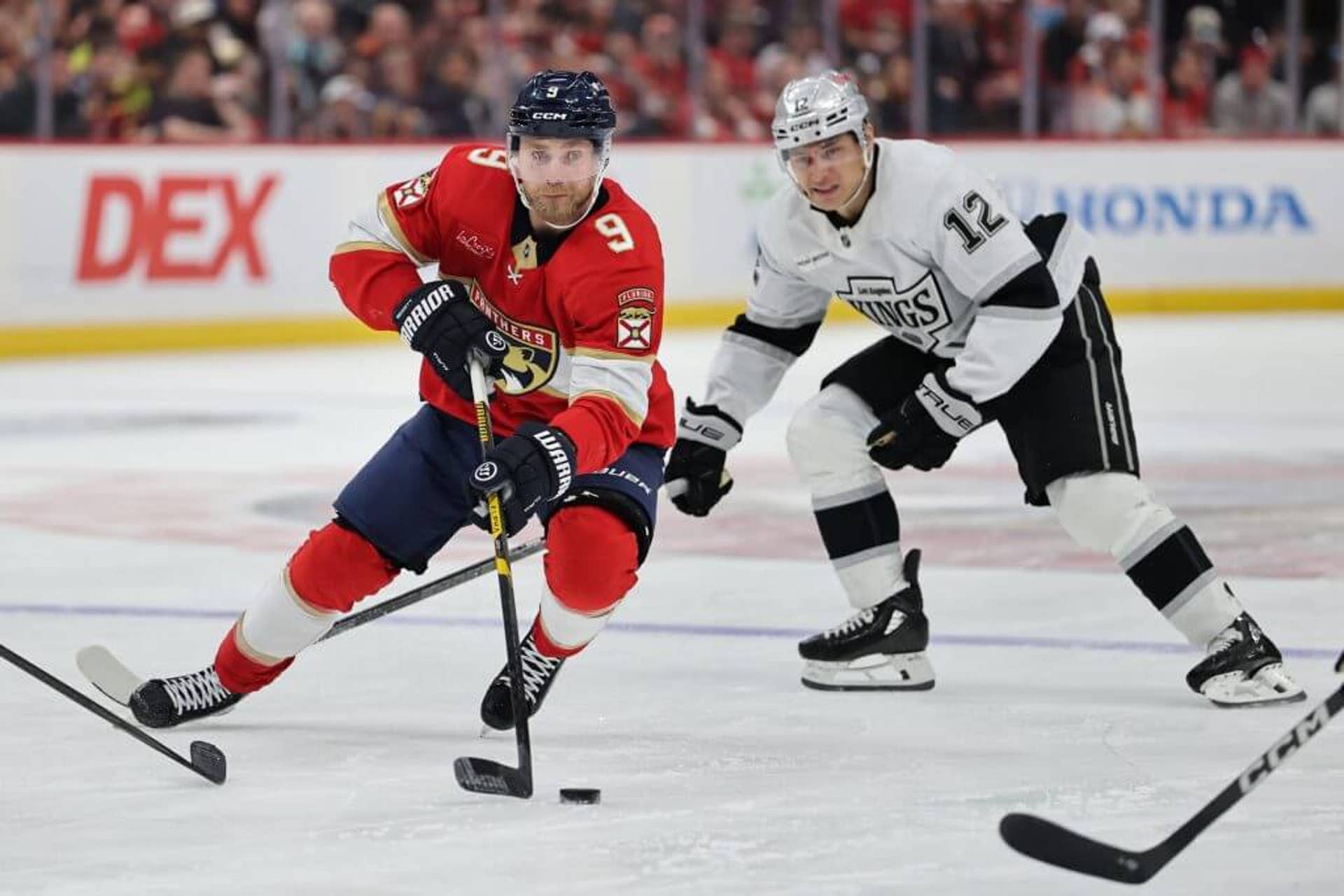 Sam Bennett of the Florida Panthers skates ahead of Trevor Moore of the Los Angeles Kings.