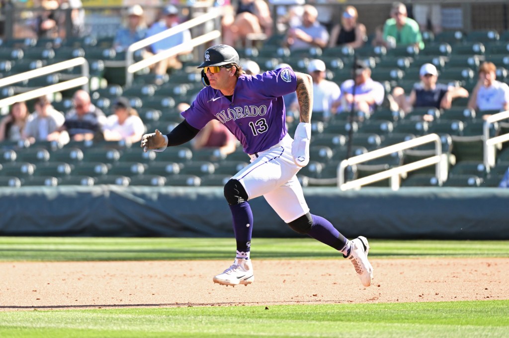 A Colorado Rockies player running across the field during a game.