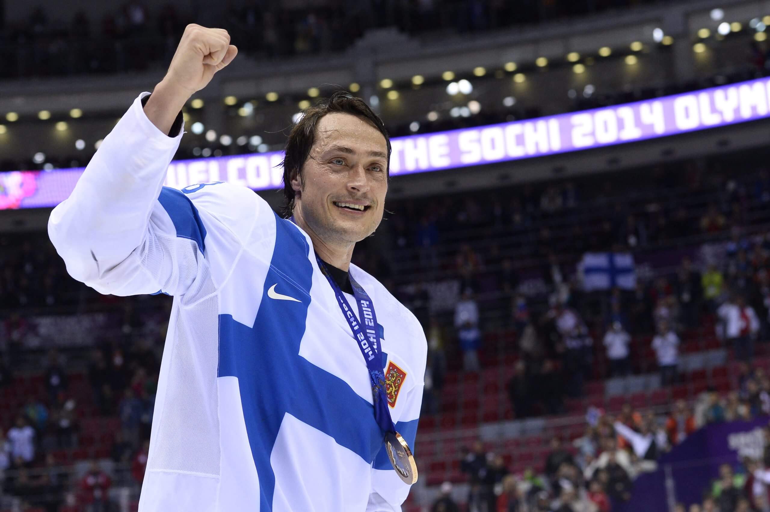 Teemu Selanne raises a fist in celebration while wearing a medal at the Sochi Olympics.