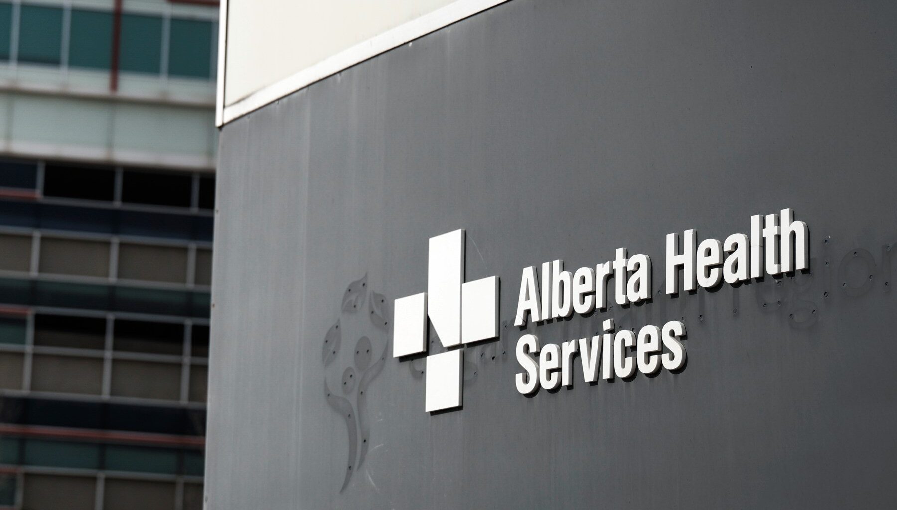 Photo of a sign on the exterior of a building that reads "Alberta Health Services."