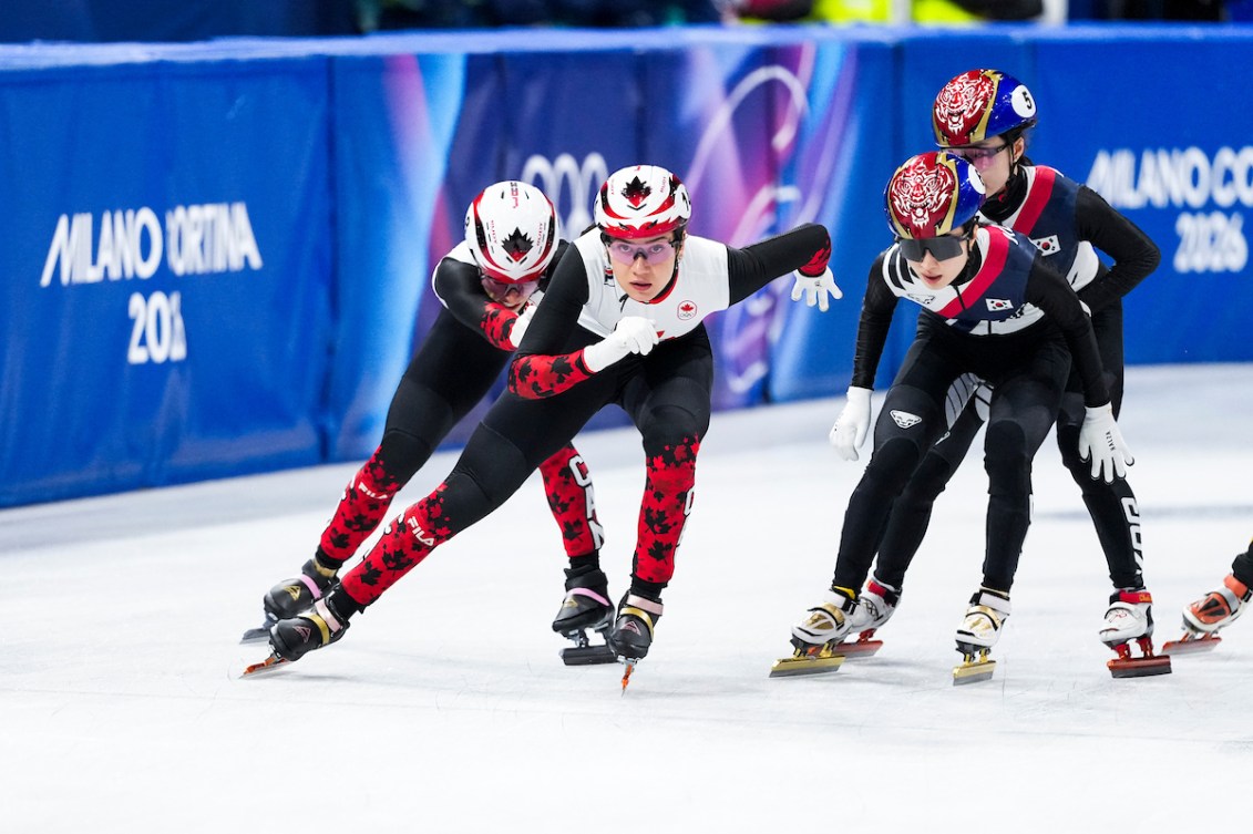 Florence Brunelle and Courtney Sarault exchange during short track relay competition.