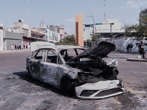 A vehicle sits charred after being set on fire in Mexico.