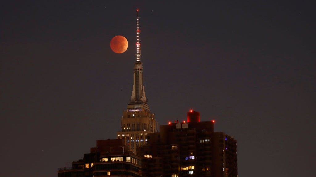 The blood-red full Beaver Moon passes behind the Empire State Building during a total lunar eclipse on November 8, 2022