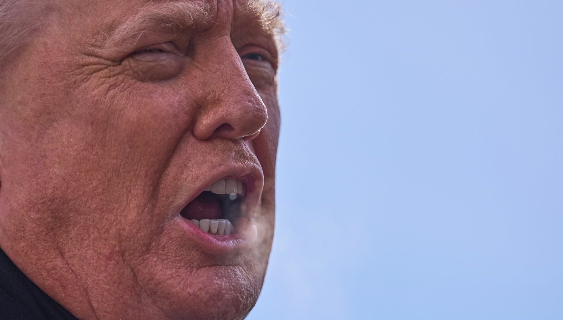 Close up of United States president Donald Trump's face in three-quarters profile.