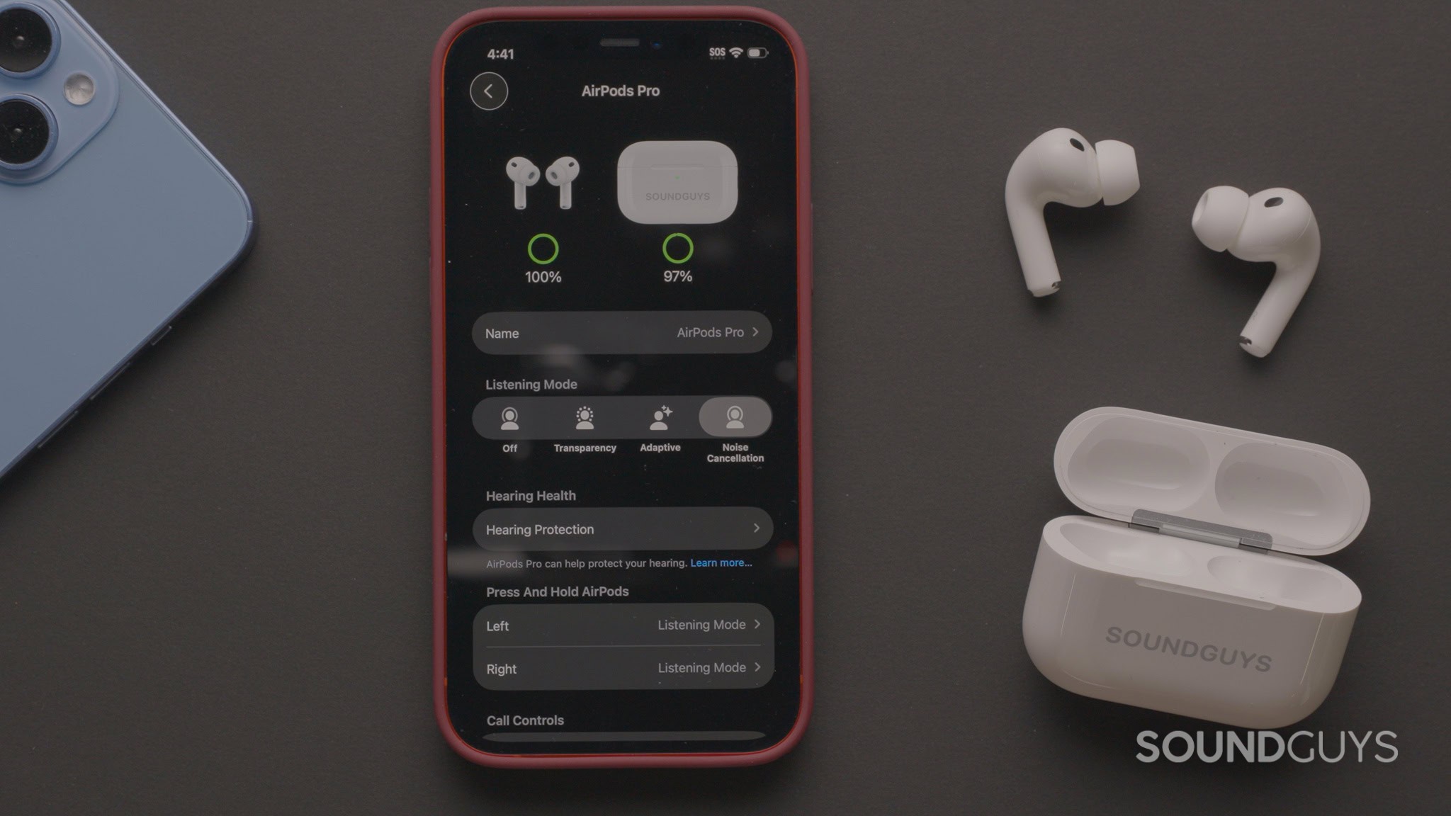 A photograph of AirPods with the settings menu of iOS on an iPhone's screen.