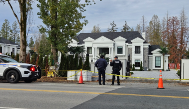 Police officers investigate a shooting outside a Surrey home