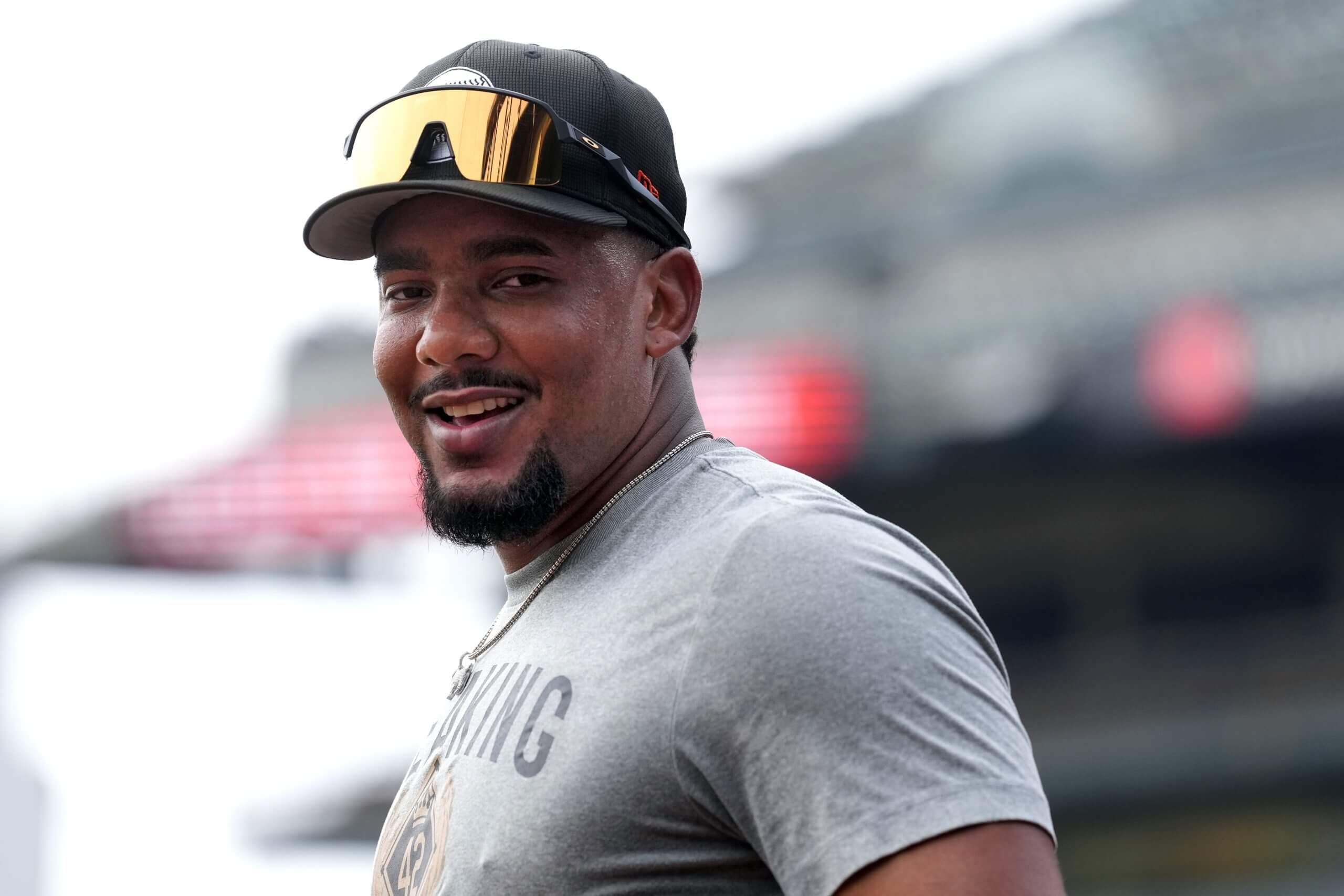 Jerar Encarnacion, in a gray T-shirt and with his sunglasses resting on the bill of his cap, looks on before a game at Oracle Park.