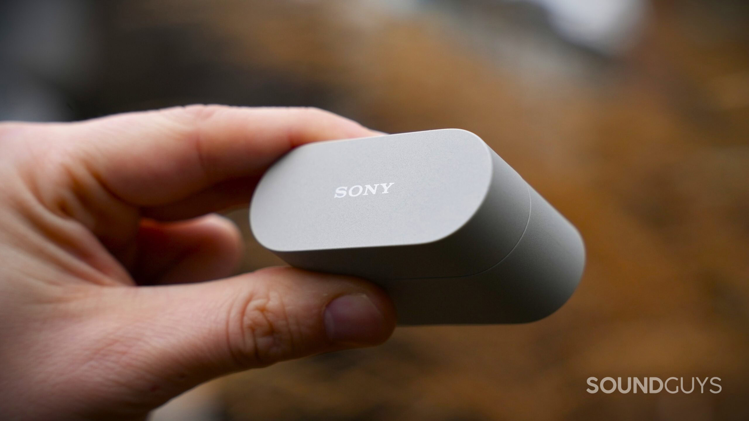 a hand holding the sony wf-1000xm6 case closed a hand holding the sony wf-1000xm6 case closed