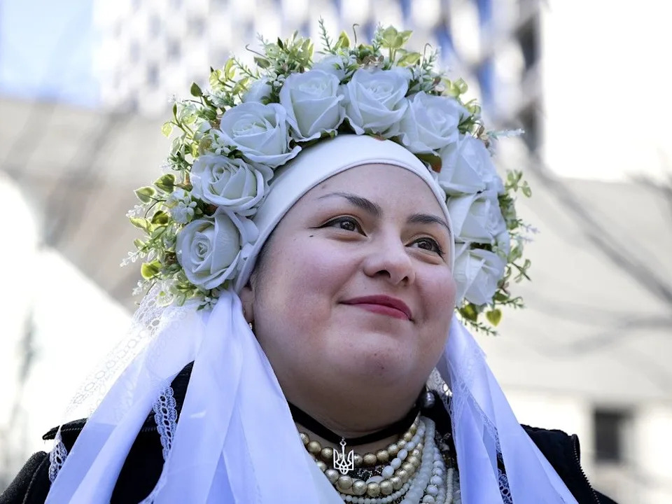 A woman wears a colourful headdress in Phillip’s Square in Montreal as hundreds gather to mark the fourth anniversary of Russia’s invasion of Ukraine.