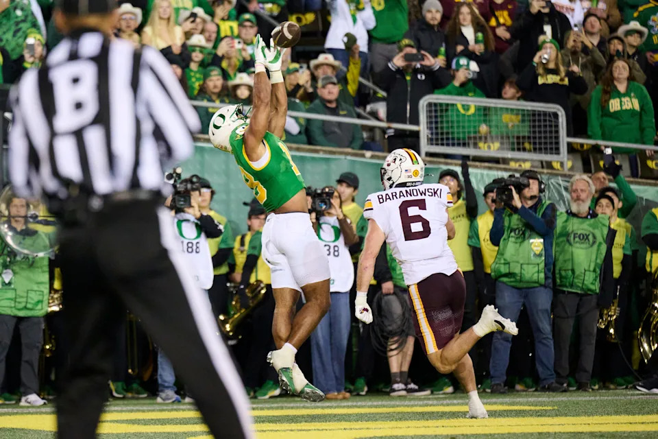 Nov 14, 2025; Eugene, Oregon, USA; Oregon Ducks tight end Kenyon Sadiq (18) catches a touchdown pass during the first half against Minnesota Golden Gophers linebacker Maverick Baranowski (6) at Autzen Stadium. Mandatory Credit: Troy Wayrynen-Imagn Images
