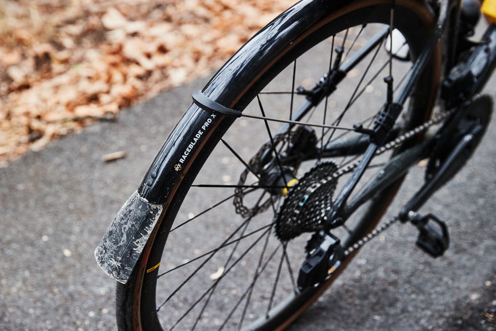 Close-up of a bicycle wheel and components on a roadway. Close-up of a bicycle wheel and components on a roadway.