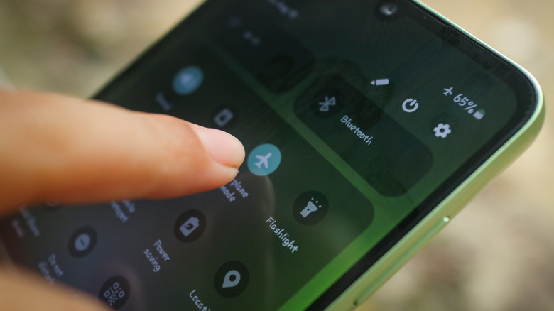 Person activating airplane mode on an Android smartohone