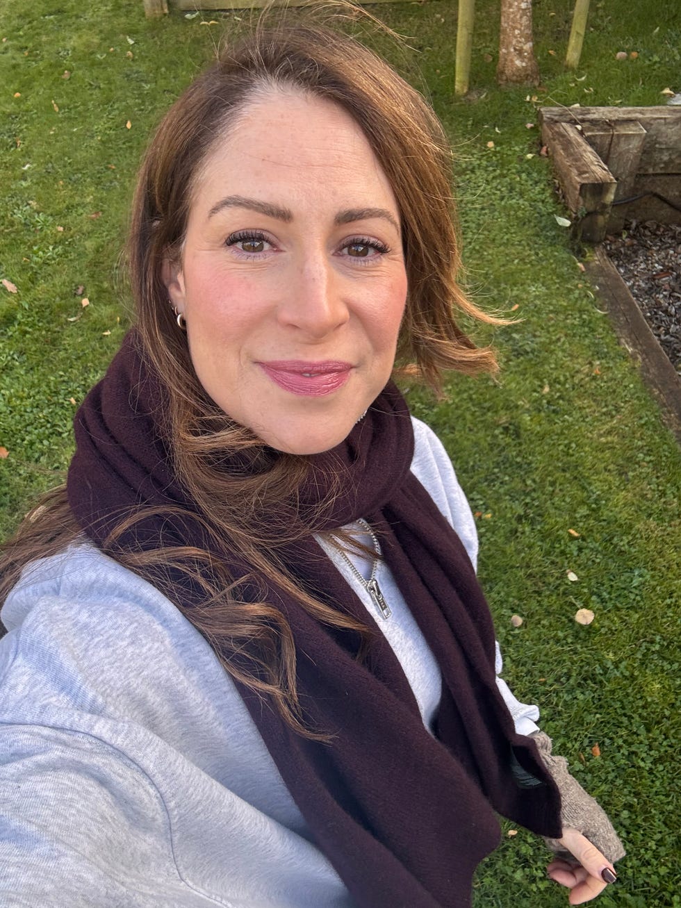 person wearing a scarf sweater and silver necklace outdoors person wearing a scarf sweater and silver necklace outdoors