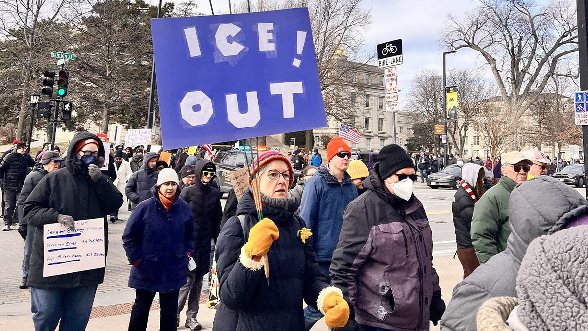 Protesters gather, some holding signs, before marching together through downtown.