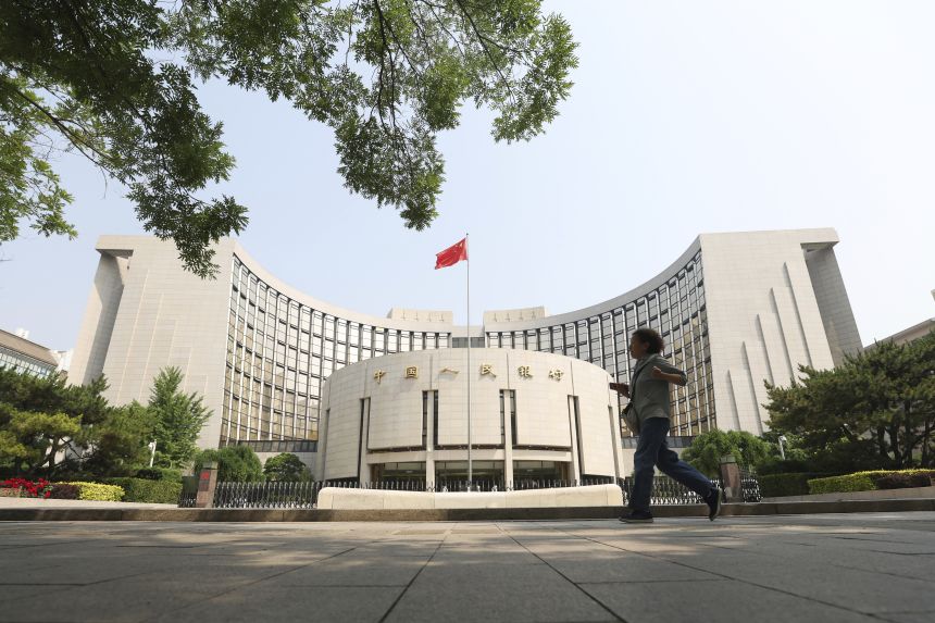 A citizen walks past the headquarters of the People's Bank of China (PBC), the central bank of China in Beijing, China, on May 20, 2025.