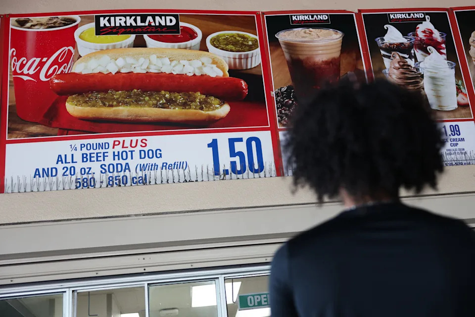 A customer waits in line to order below signage for the Costco Kirkland Signature $1.50 hot dog and soda combo, which has maintained the same price since 1985 despite consumer price increases and inflation, at a food court outside a Costco Wholesale warehouse store in Hawthorne, California on August 27, 2025. (Photo by Patrick T. Fallon / AFP) (Photo by PATRICK T. FALLON/AFP via Getty Images)          