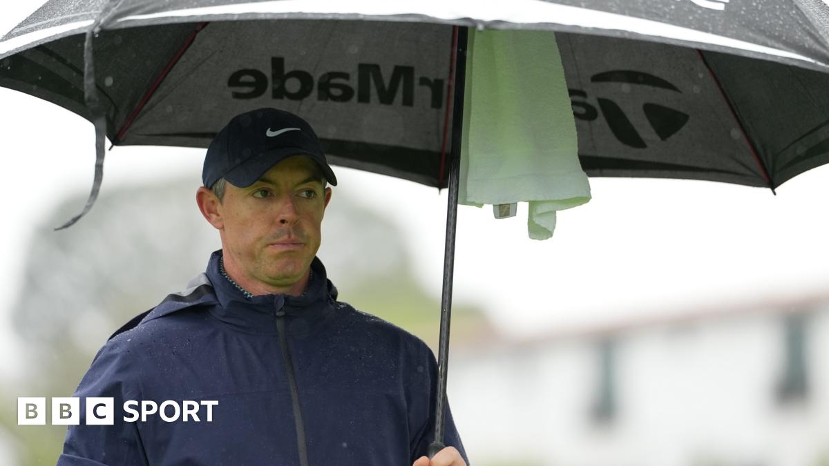 Rory McIlroy sheltering under an umbrella during round one of the Genesis Invitational