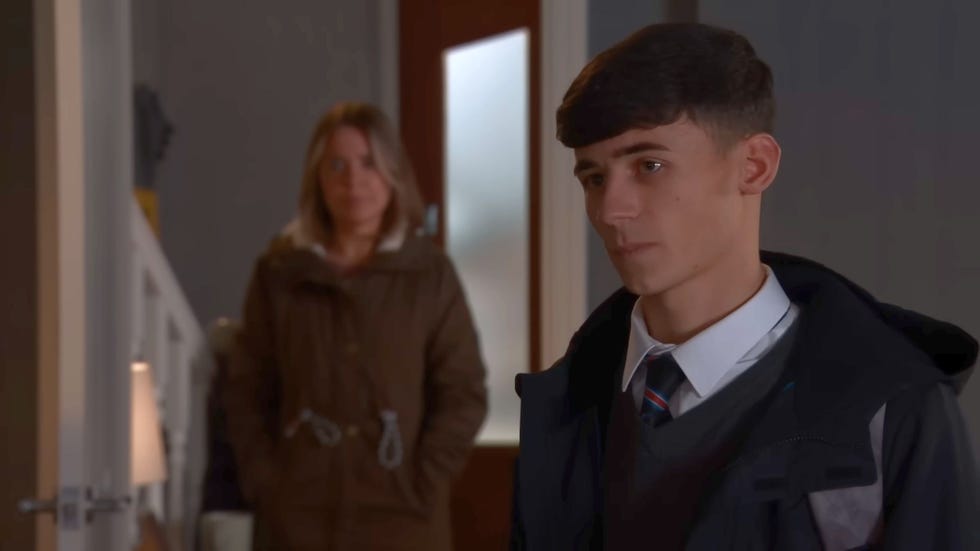 coronation street jack webster in school uniform and coat, with and out of focus abi in background