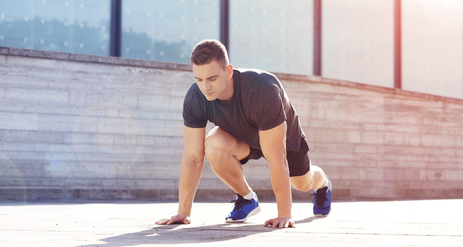 Young male outdoors in a plank with right leg forward