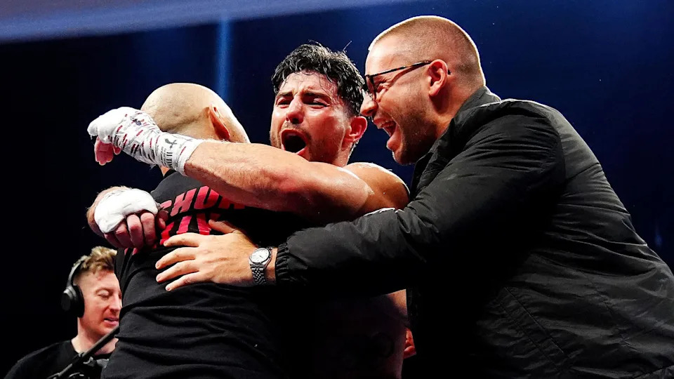 Josh Kelly hugs Adam Booth and Frank Smith