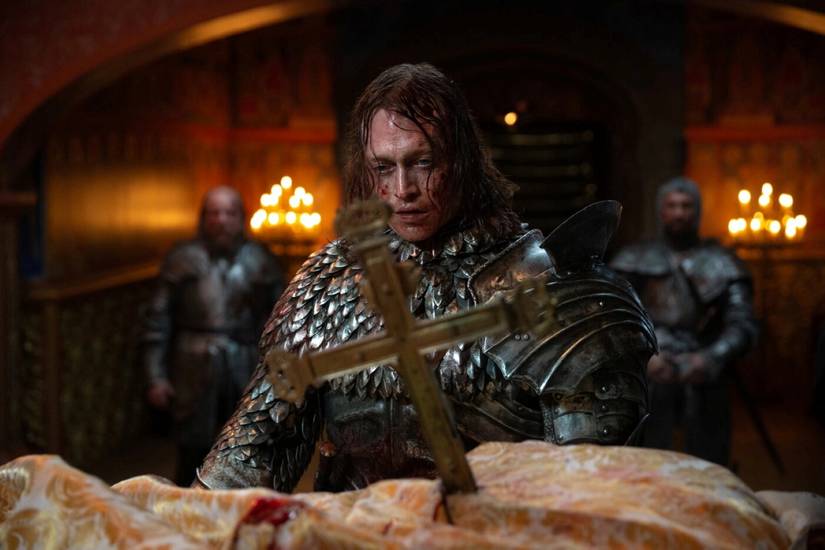Vlad the Impaler (Caleb Landry Jones) looks on mournfully at a priest he has stabbed with a crucifix in a scene from Luc Besson's version of Dracula.