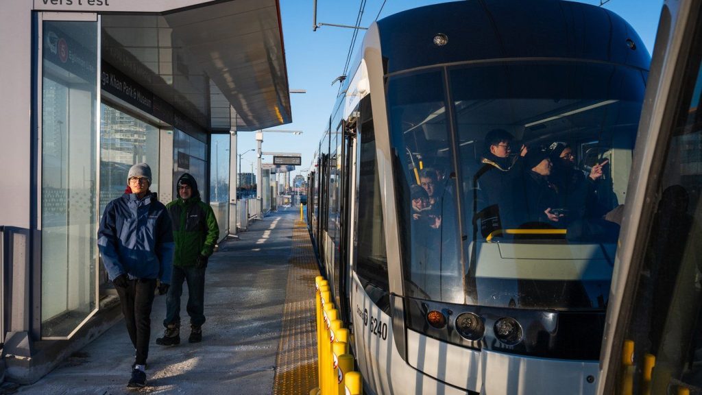 People ride the Eglinton Crosstown LRT on its first day of service in Toronto