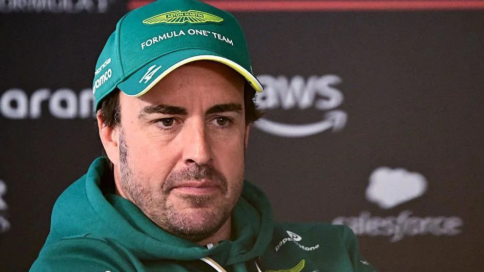 Fernando Alonso wearing an Aston Martin cap and hoodie at a news conference during Bahrain testing