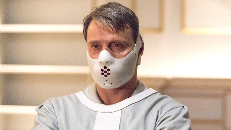 Hannibal Lecter wears a white face mask while wrapped in a straight jacket in 