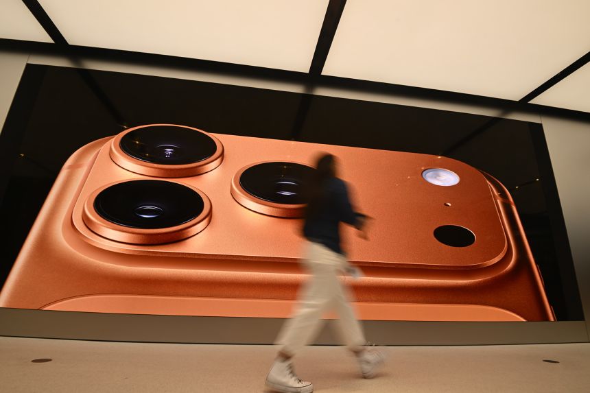 A consumer passes in front of a billboard displaying Apple's newly launched iPhone 17 on September 19, 2025 in Sydney, Australia.