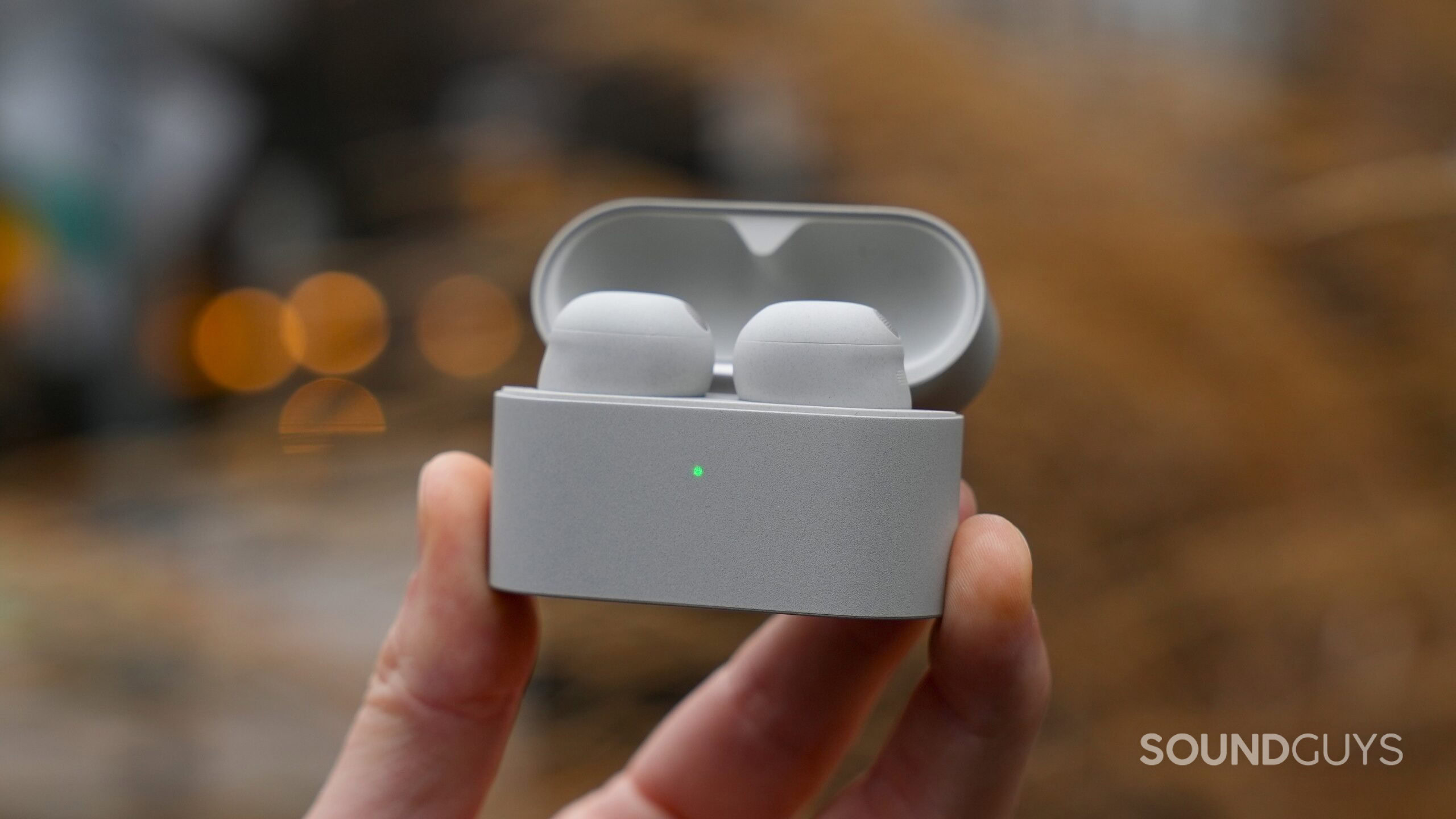 holding the sony wf-1000xm6 open case lid a hand holding the sony wf-1000xm6 inside case with the lid open