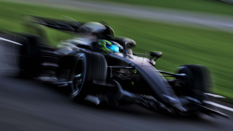 A black F1 monochrome car driving on a track before the 2026 season