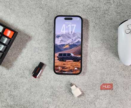 iPhone 16 Pro on desk with keyboard controller and flash drive