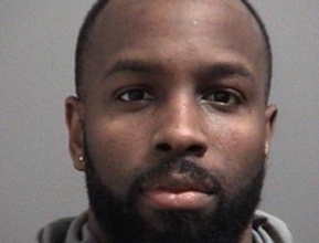 Police released headshot of a person looking directly at the camera.with short hair and a beard, wearing a hoodie, against a plain grey background.