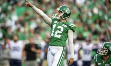 Kicker Brett Lauther points ahead of a kick during a CFL game.