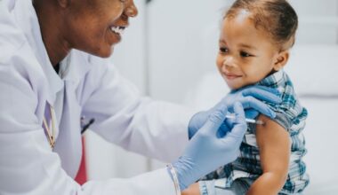 A stock image of a doctor giving a baby a vaccine in her arm.
