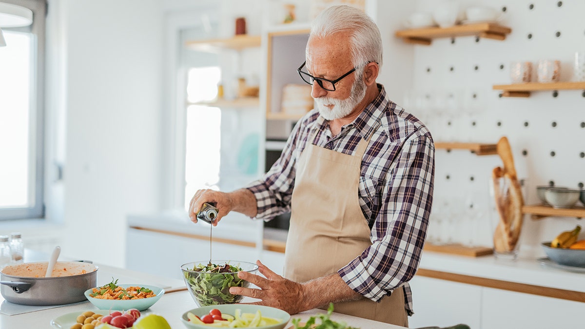 Man with gray hair at home cooking at home