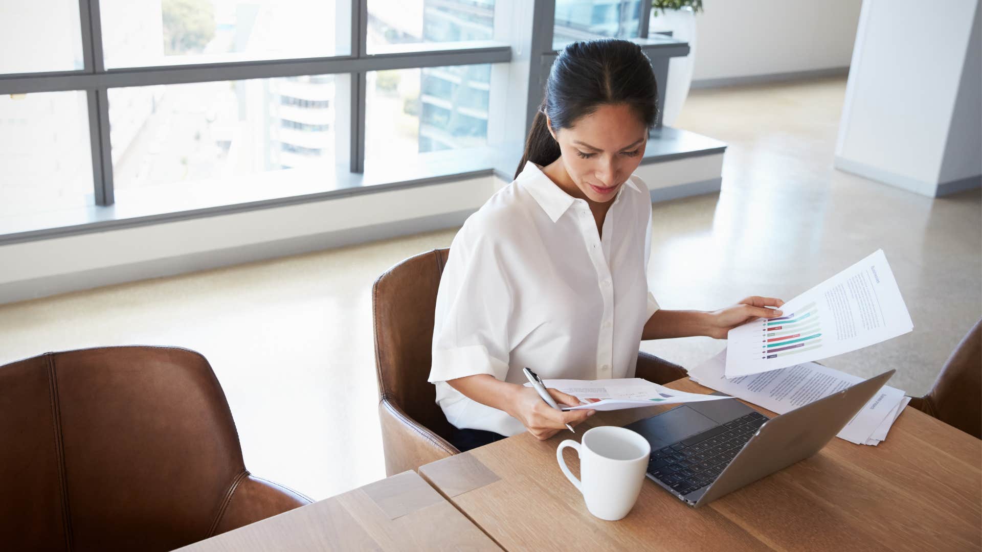 Busy millennial sits at work showing source of stress