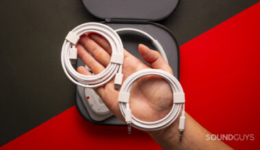 a hand holding white usb-c and 3.5mm cables