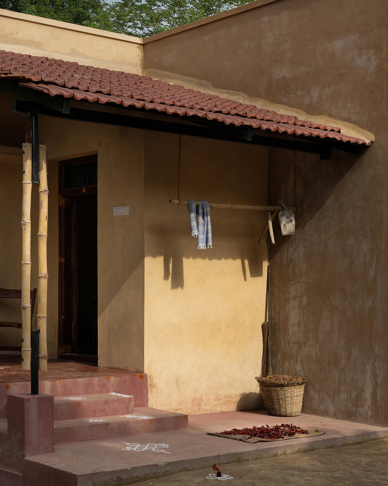 thousands of reclaimed bricks shape rural residence amid agricultural fields in india