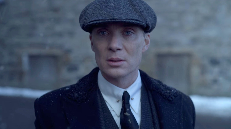 Tommy Shelby (Cillian Murphy) stands looking expectantly in a street in Peaky Blinders