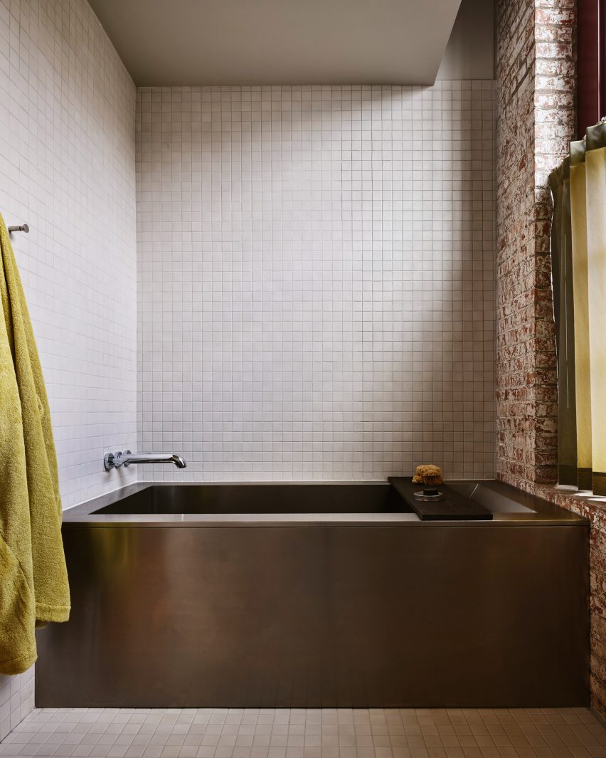 Bathtub within a white-tiled niche