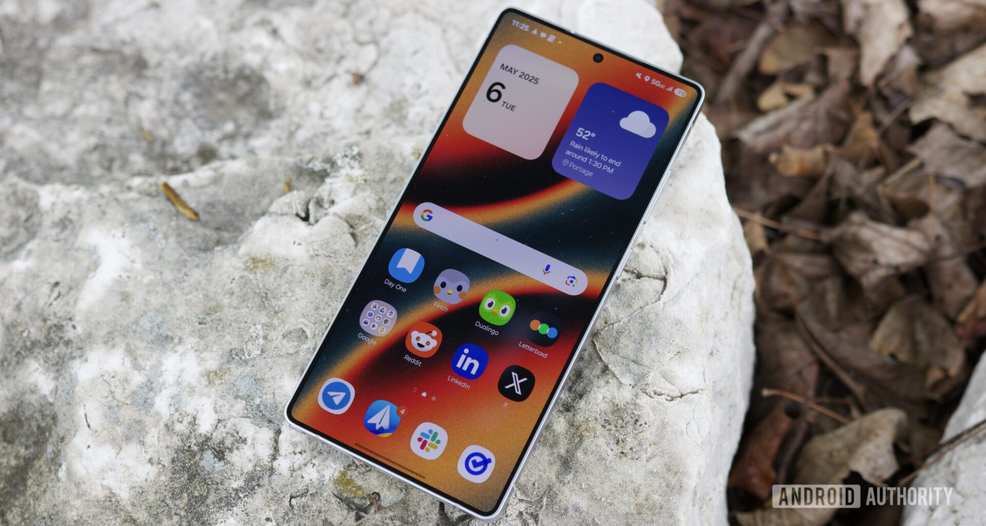 The Samsung Galaxy S25 Ultra laying outside with its display on.